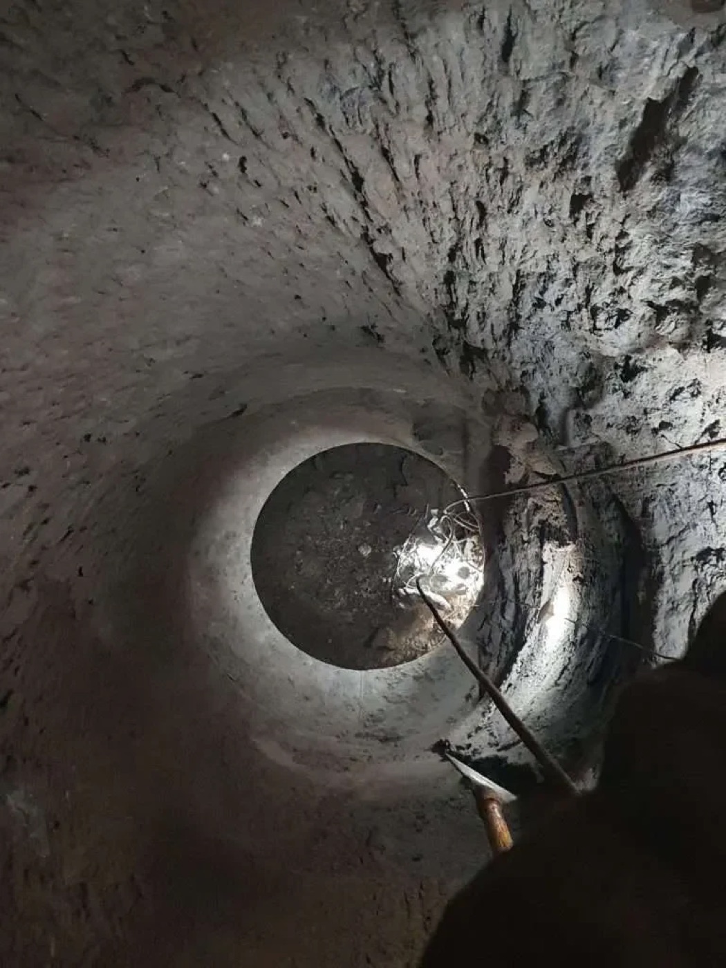 Looking up inside a silo with a technician on rope