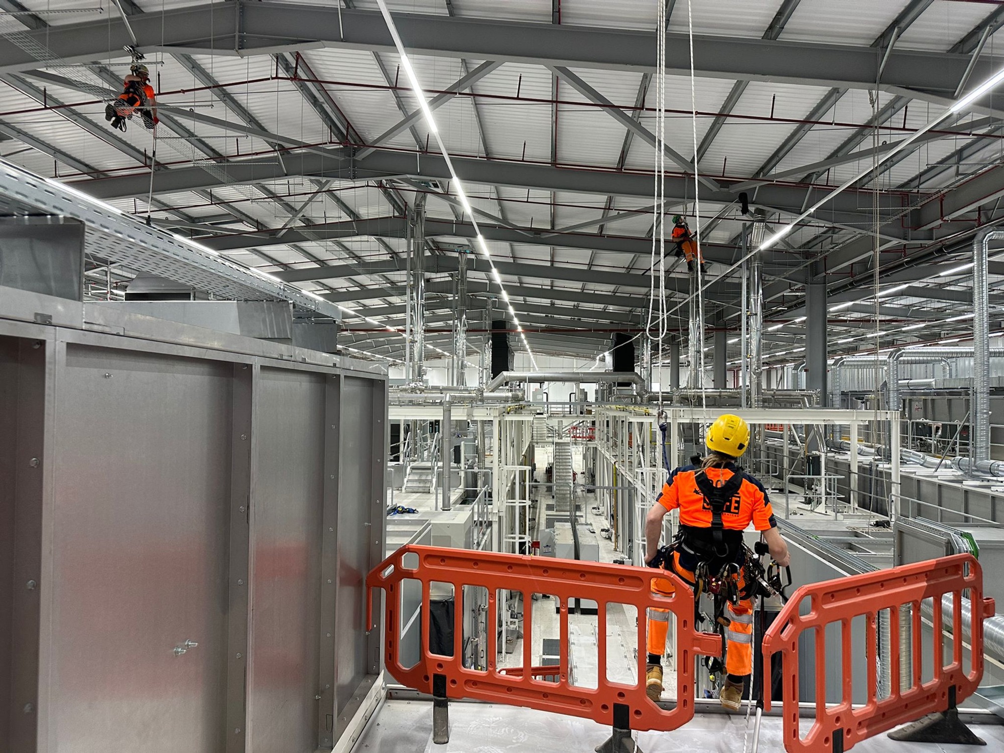 Rope access technician preparing to descend inside a large warehouse